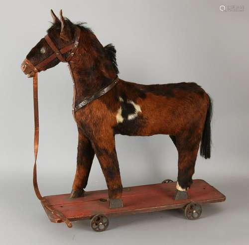 Antique wooden rocking horse covered with cowhide.