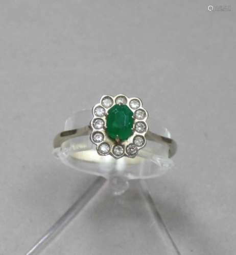 RING, besetzt mit einem ovalen Smaragd, umgeben von einer Vielzahl kleiner Brillanten; 750er