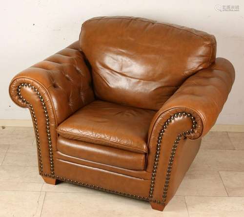 Brown leather armchair with copper nails and wooden