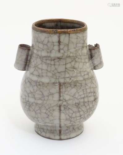 A Chinese Ge vase with a crackle glaze, twin tubular handles and a copper rim. Approx.