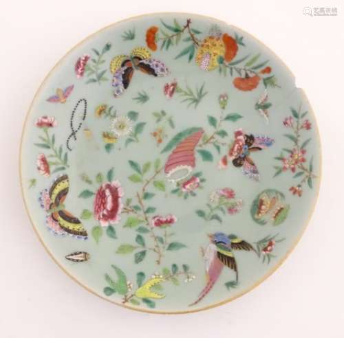 A Cantonese plate on a pale green ground decorated with birds, butterflies, flowers, and foliage,