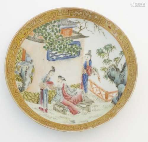 A small Chinese famille rose plate decorated with figures on a terrace within a landscape with a