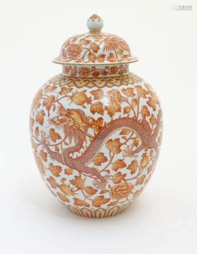 A Chinese orange and white lidded ginger jar decorated with dragons,