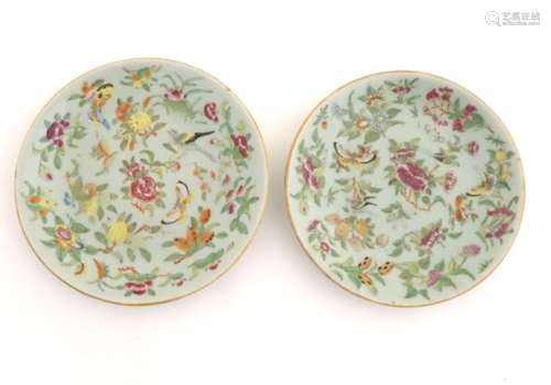 Two Cantonese plates on a pale green ground decorated with birds, butterflies, flowers, and foliage,