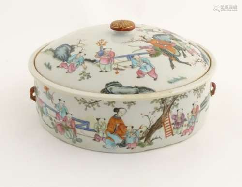 A Chinese lidded pot decorated with figures in a garden with flowers, fruit, vases etc.