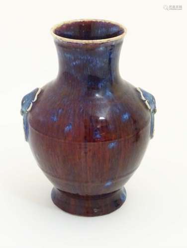 A Chinese high fired, sang de boeuf baluster vase with ring handle decoration.