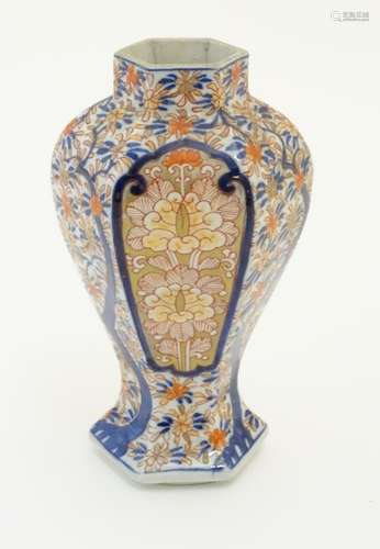 An Imari style hexagonal vase with panelled floral decoration and gilt highlights. 7 1/2