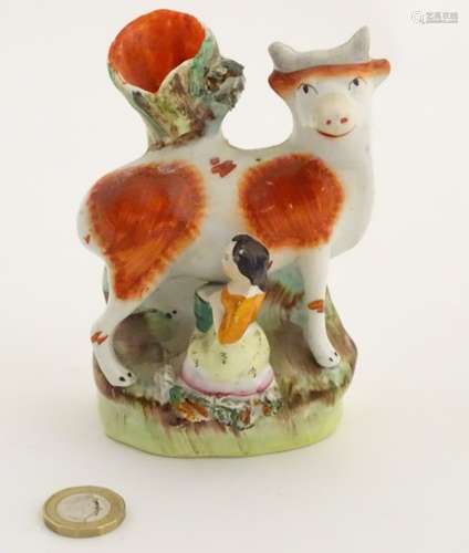 A 19thC flatback Staffordshire Pottery spill vase formed as a milk maid milking a cow. Approx.