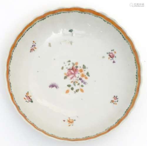 A scallop edge dish with hand painted floral decoration. Approx. 6