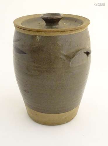 A two tone studio pottery lidded stoneware pot with twin handles and stylised brushwork decoration.