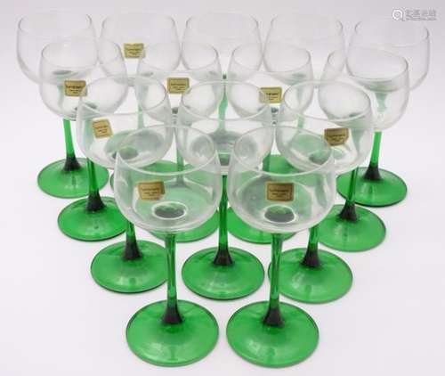 A collection of thirteen mid-20thC retro wine glasses by Luminarc, each with green stem,