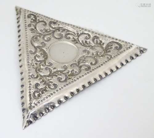 A Victorian silver pin dish of triangular form with embossed decoration.