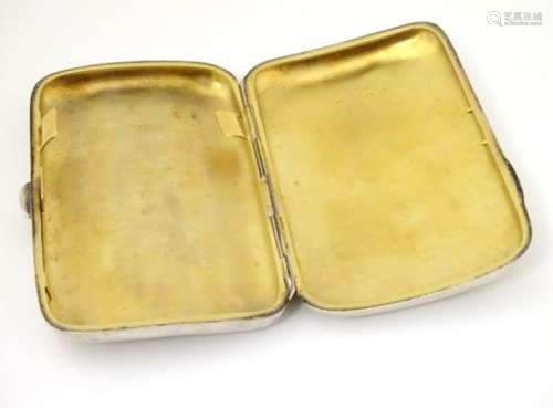 A silver cigarette / cigar case of shaped form with gilded interior.