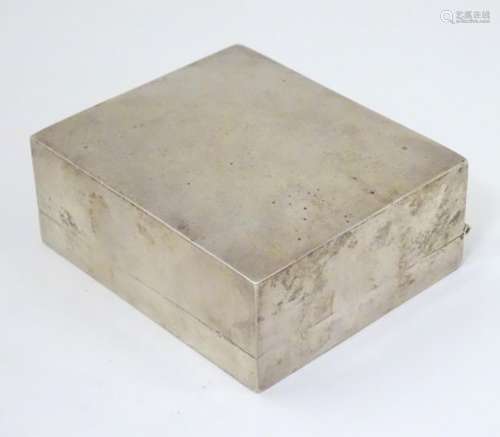 A silver table top cigarette box with wood lined interior.