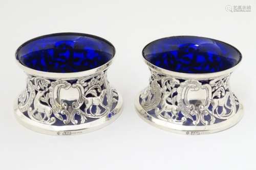 A pair of Irish silver potato rings with ornate pierced scroll, floral and dog decoration.