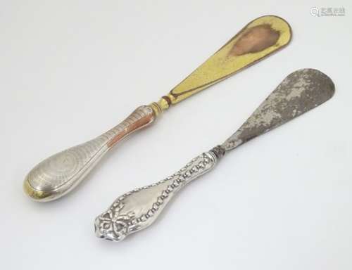 A silver handled shoe horn, together with another.