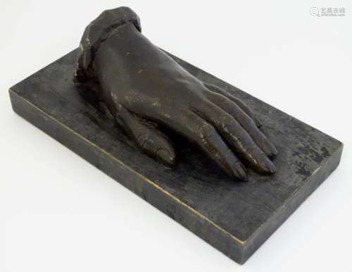 A folk art carved wooden model of a left hand on a rectangular base. Approx. 3 1/4