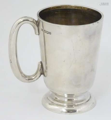 A silver mug with loop handles hallmarked Sheffield 1954 maker Walker & hall.