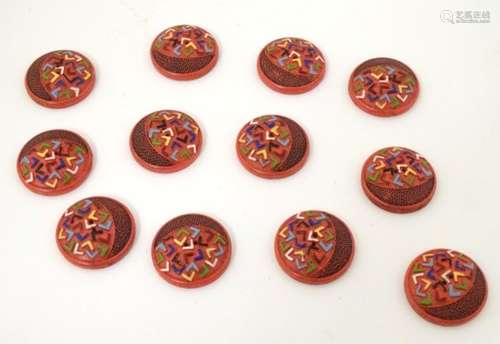 12 French retro buttons with two holes, decorated with colourful chevrons in relief on a red ground.