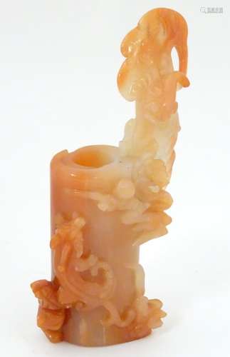 A Chinese peach / coral coloured jade brush pot of carved rolled scroll form with carved bat etc.