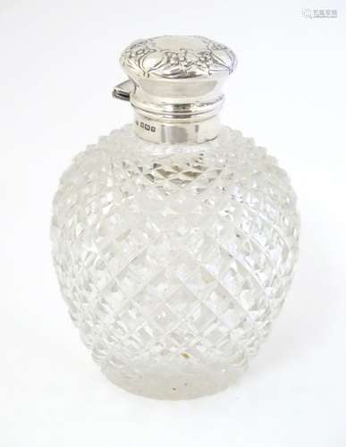 A glass scent bottle with hobnail cut decoration with silver mounts and top hallmarked Sheffield