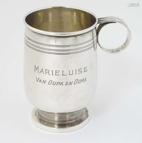 An Art Deco silver Christening mug with banded decoration and ring handle.