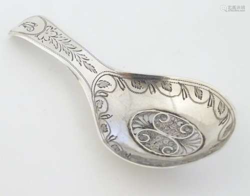 A Geo III silver caddy spoon with engraved decoration and filigree oval to bowl.