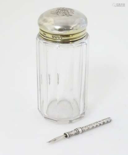 A glass dressing table jar with silver top hallmarked London 1882 maker FF.