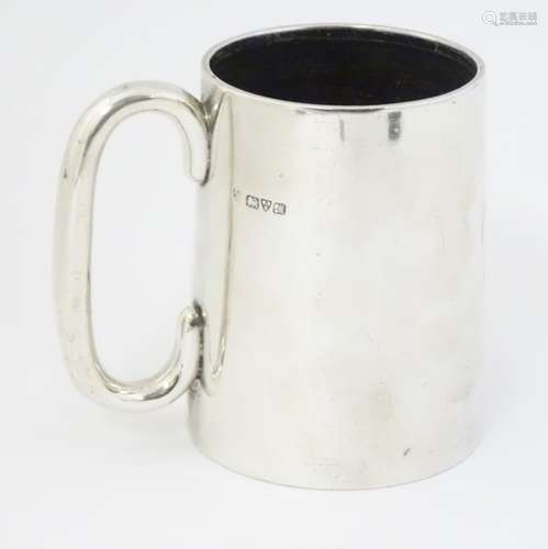 A silver mug with loop handle hallmarked Chester 1912 maker Haseler Borthers.