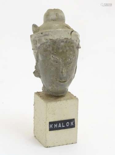 An East Asian ceramic head mounted on a square stone plinth labelled 'Khalok', 5 1/4