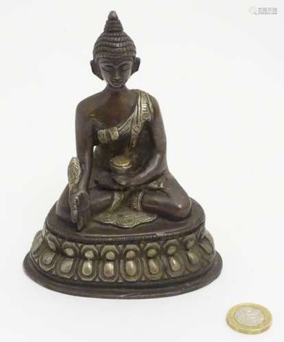 A cast bronze Nepalese Buddha sat cross legged on a Lotus Petal base, touching earth.