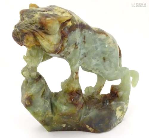 A Chinese jade / hardstone sculpture carved as a prowling tiger. Approx. 7 1/2