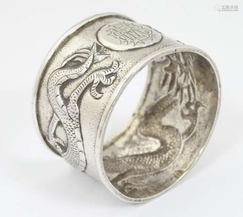 Chinese Export Silver : A white metal napkin ring with dragon decoration,