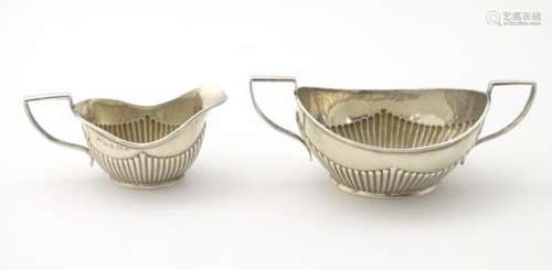 A silver cream jug and sugar hallmarked Birmingham 1910 and 1912 maker Henry Williamson Ltd.