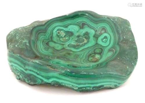 A malachite specimen with polished sides and dished centre.