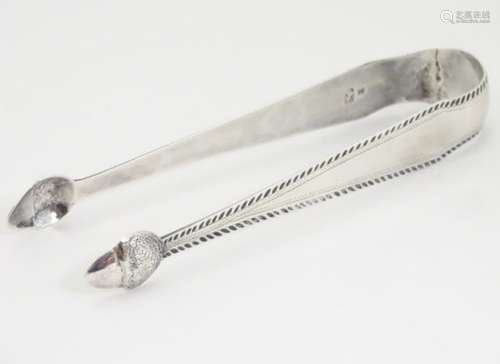 Geo III silver sugar tongs with bright cut decoration and acorn formed grips. With incuse duty mark.