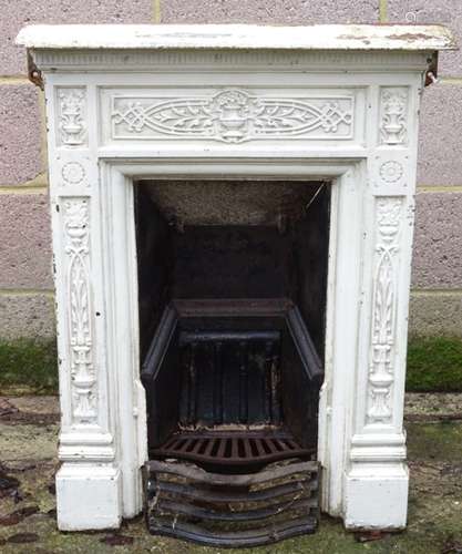 An Edwardian cast iron fireplace, having panelled classical decoration and white painted finish,