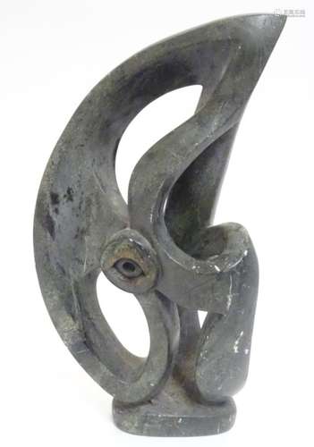 A large abstract soapstone sculpture with central eye motif, possibly a stylised eagle,