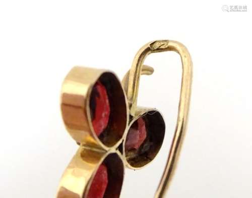 A 9ct gold stick pin set with trio of garnets and central seed pearl. 2” long.