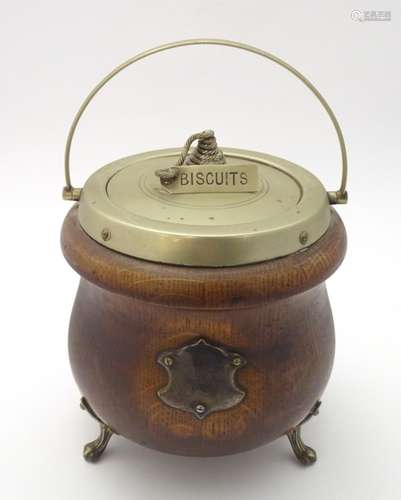 A late 19thC / early 20thC oak biscuit barrel of cauldron form raised on three feet with silver