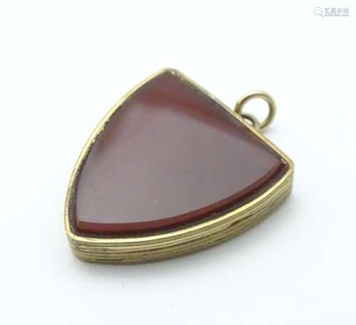 A shield shaped locket pendant set with carnelian.