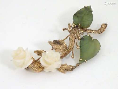 A brooch formed as a floral branch with green jade leaves and white jade flower / rose heads.