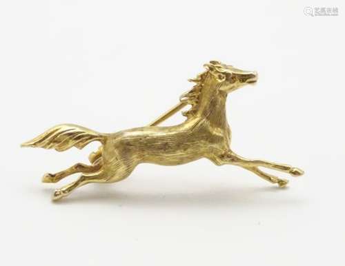 A 9ct gold brooch formed as a galloping horse,