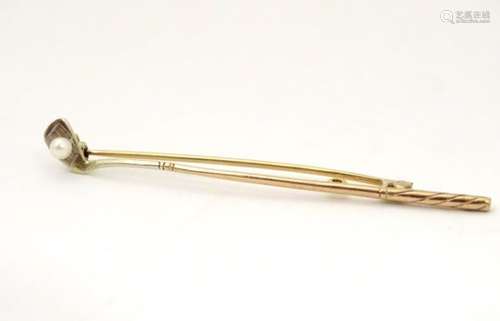 A 9ct gold bar brooch with golf club decoration with seed pearl golf ball detail.