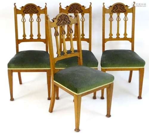 A set of four early 20thC Art Nouveau dining chairs with carved cresting rails and pierced central