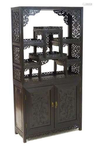 A late 19thC / early 20thC Chinese hardwood cabinet with open display shelves resting on a cupboard