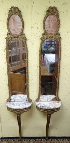 A pair of 19thC gilt wood console tales with marble tops below mirrors with carved frames and