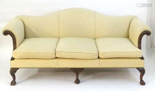 A late 19thC / early 20thC camel back settee / sofa with a carved show wood frame and three carved