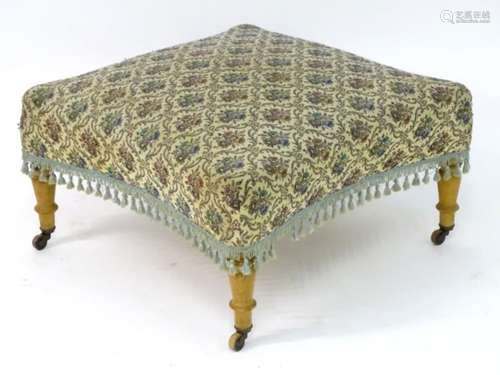 An early 20thC footstool with an upholstered sprung top and concave sides,