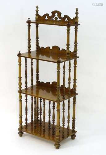 A 20thC burr walnut four tier whatnot with a shaped pierced upstand above four shelves with turned